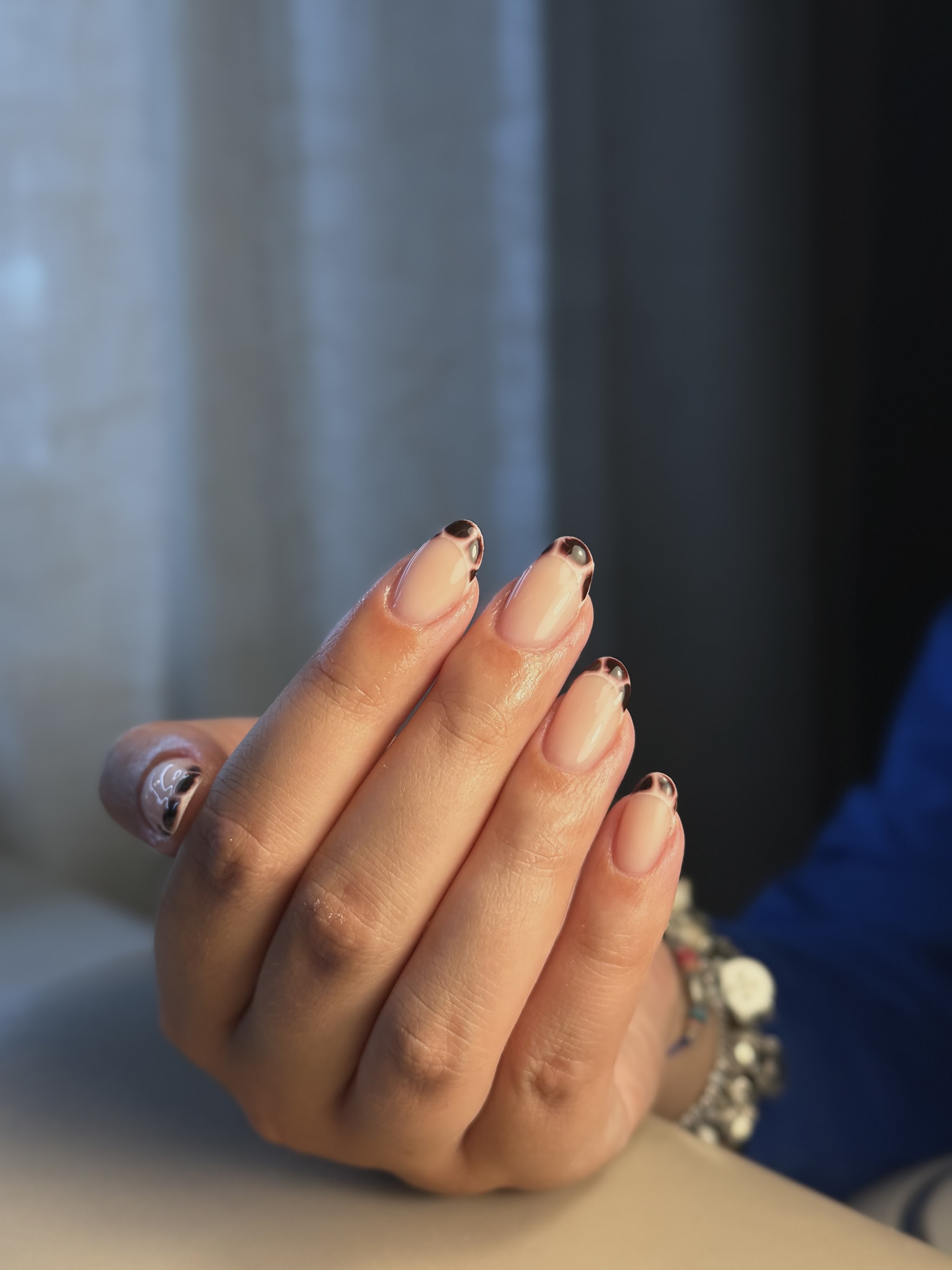 Hand met naturel nagels en donkere French tips